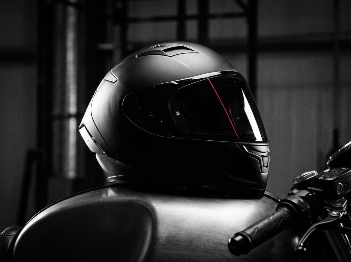 Helm auf dem Tank, rote Reflexionslinie auf dem Visier