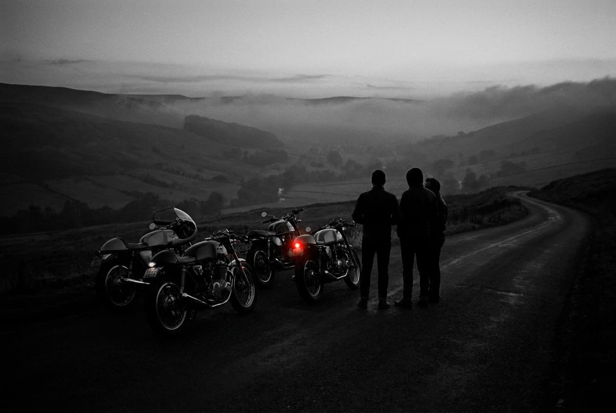 Motorradfahrer bei Dämmerung an einem Aussichtspunkt